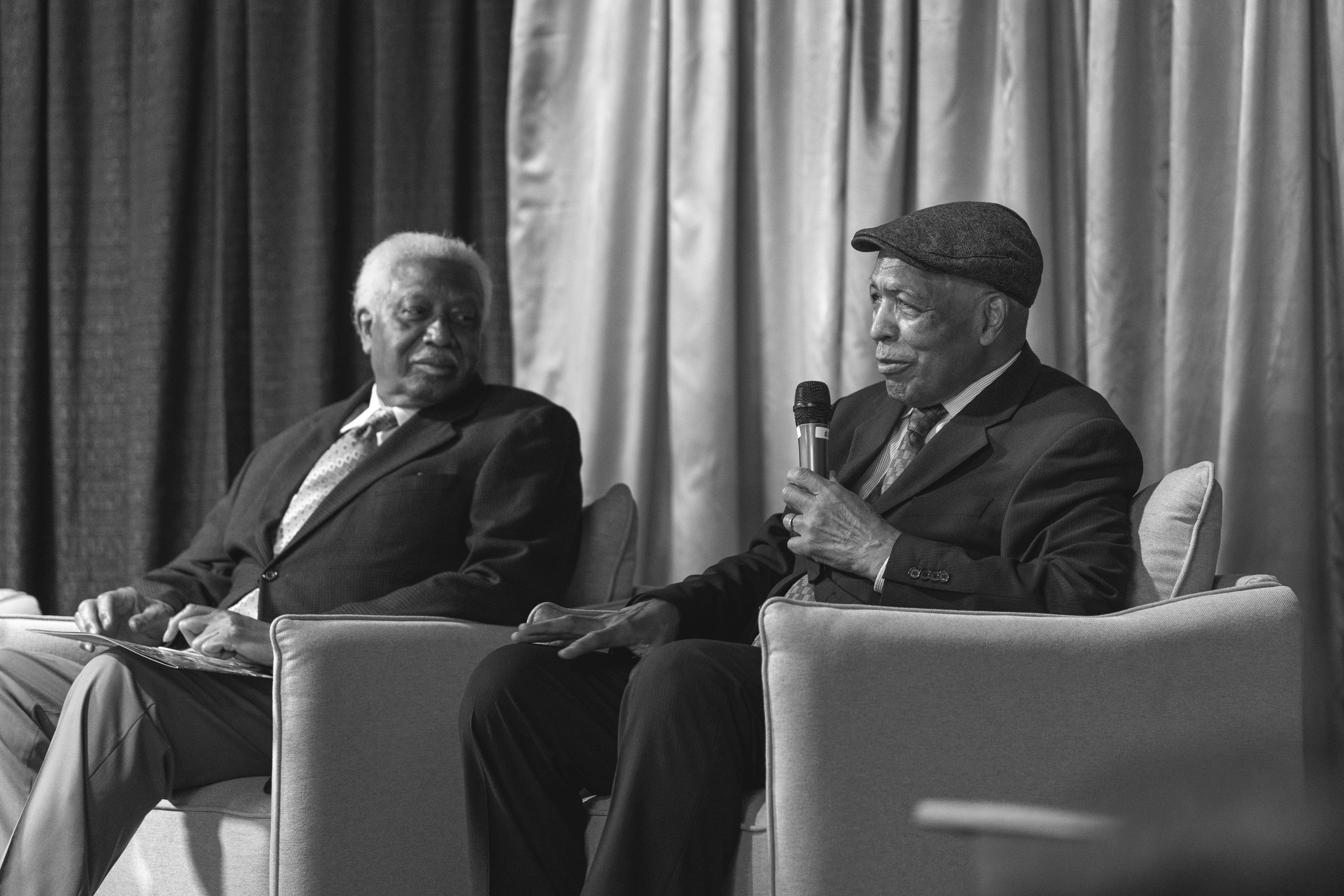 Two elders sharing their stories on stage