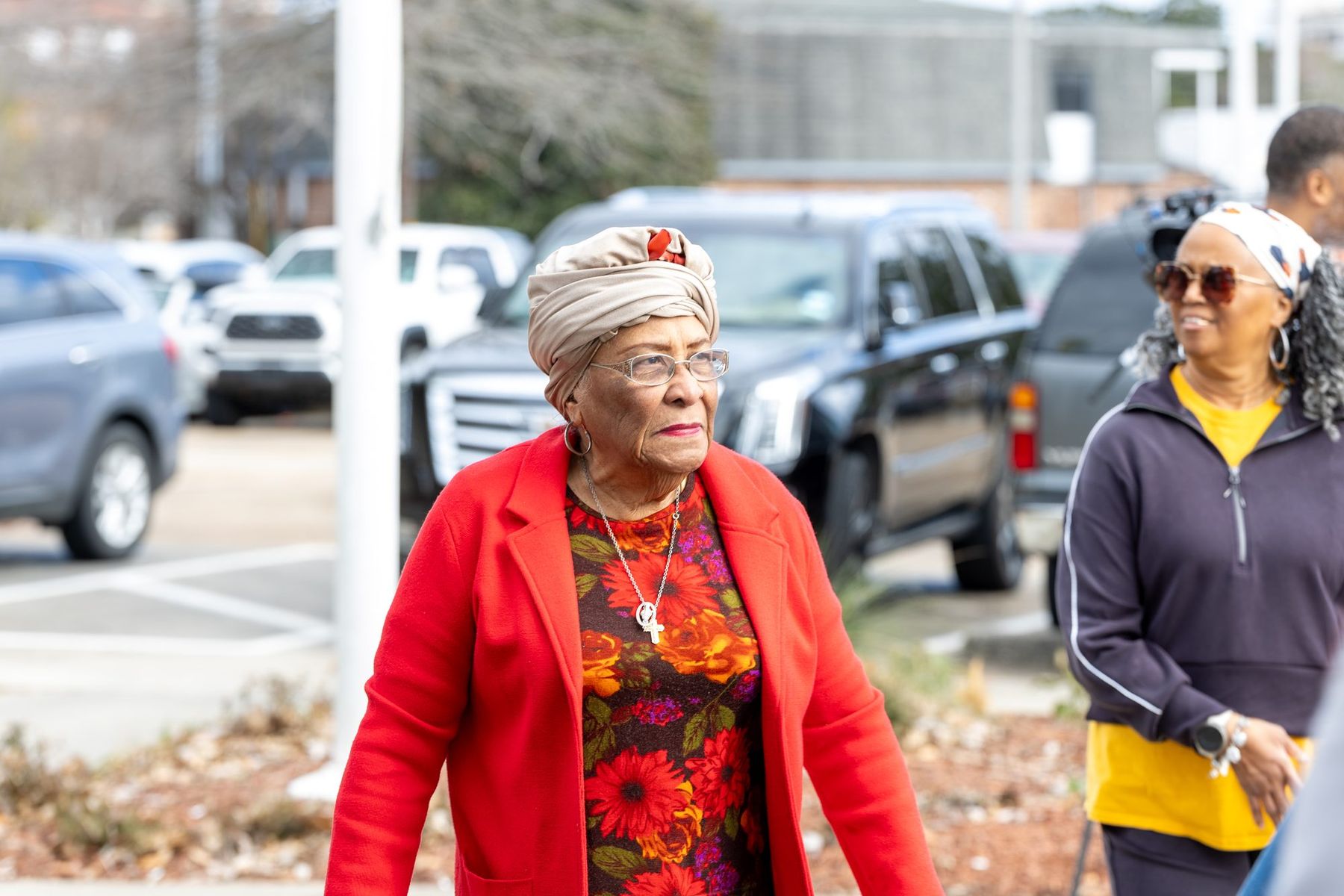 An elder in a red coat arriving
