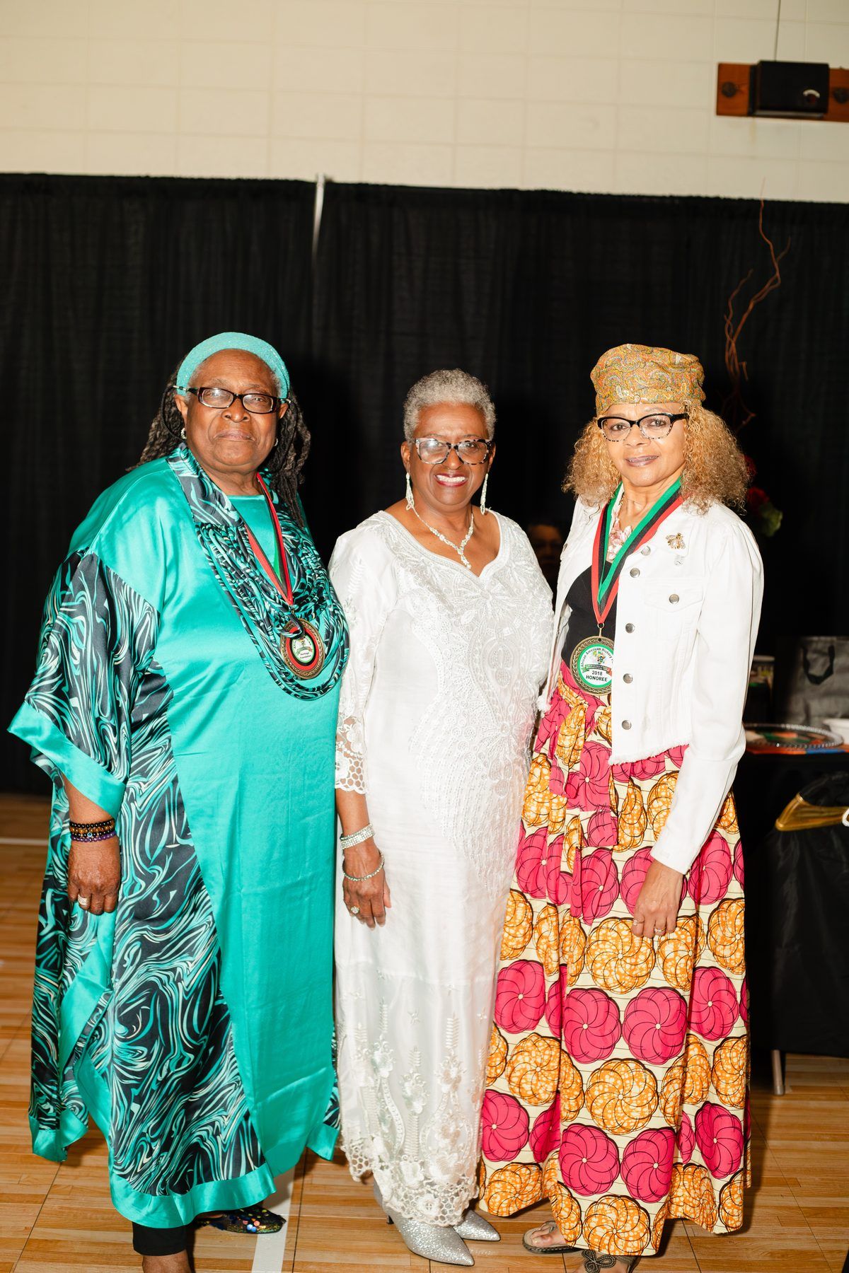 Three women in African print gowns